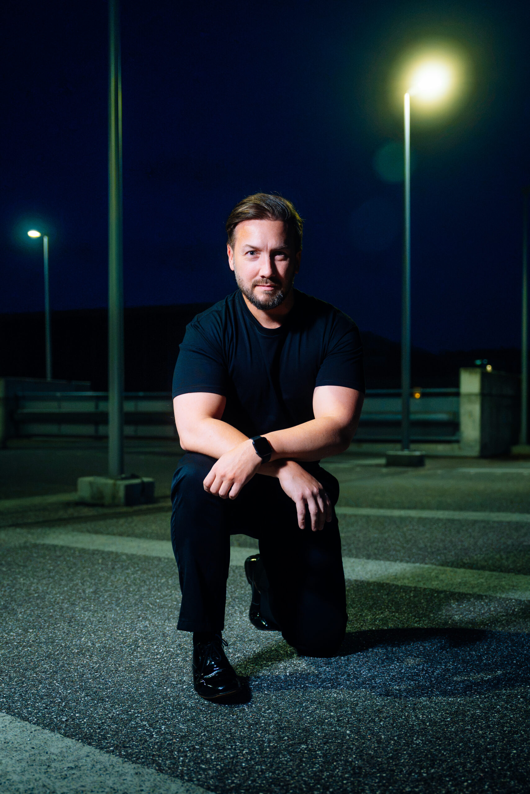 Tenor Michael Müller-Kasztelan kneeling outdoors at night
